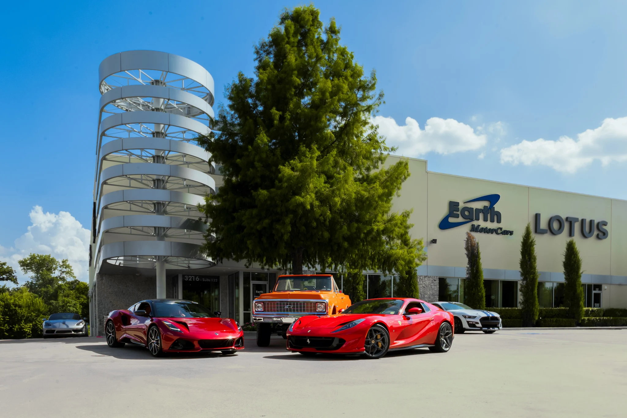 Earth MotorCars showroom in Carrollton, Texas, with luxury and exotic cars on display.