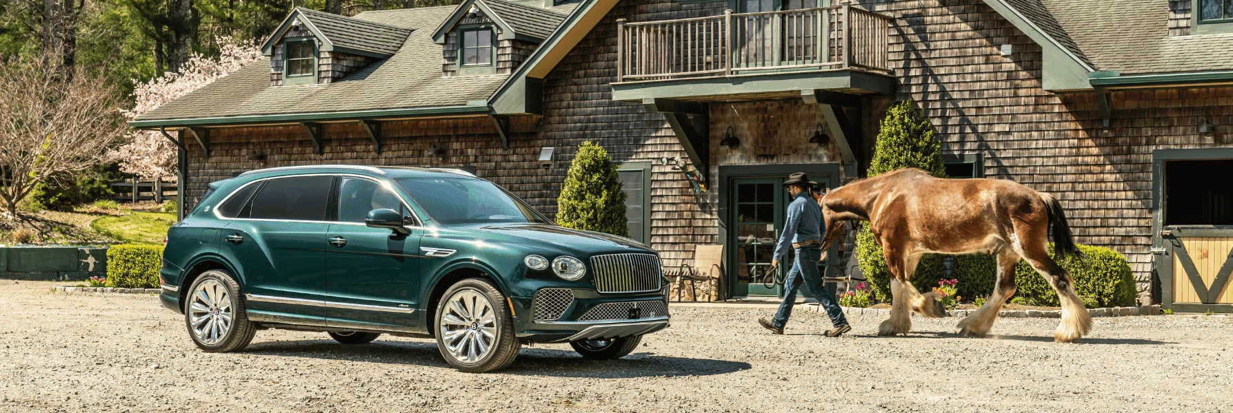 Green Bentley Bentayga outside a timber-clad stable, with a horse and its handler, in an image supplied by Holman Motorcars.