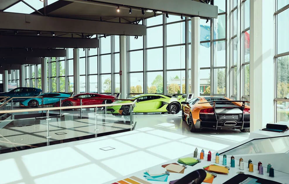 Lamborghini supercars on display in a glass-walled gallery, cover image chosen by Lamborghini Montréal.