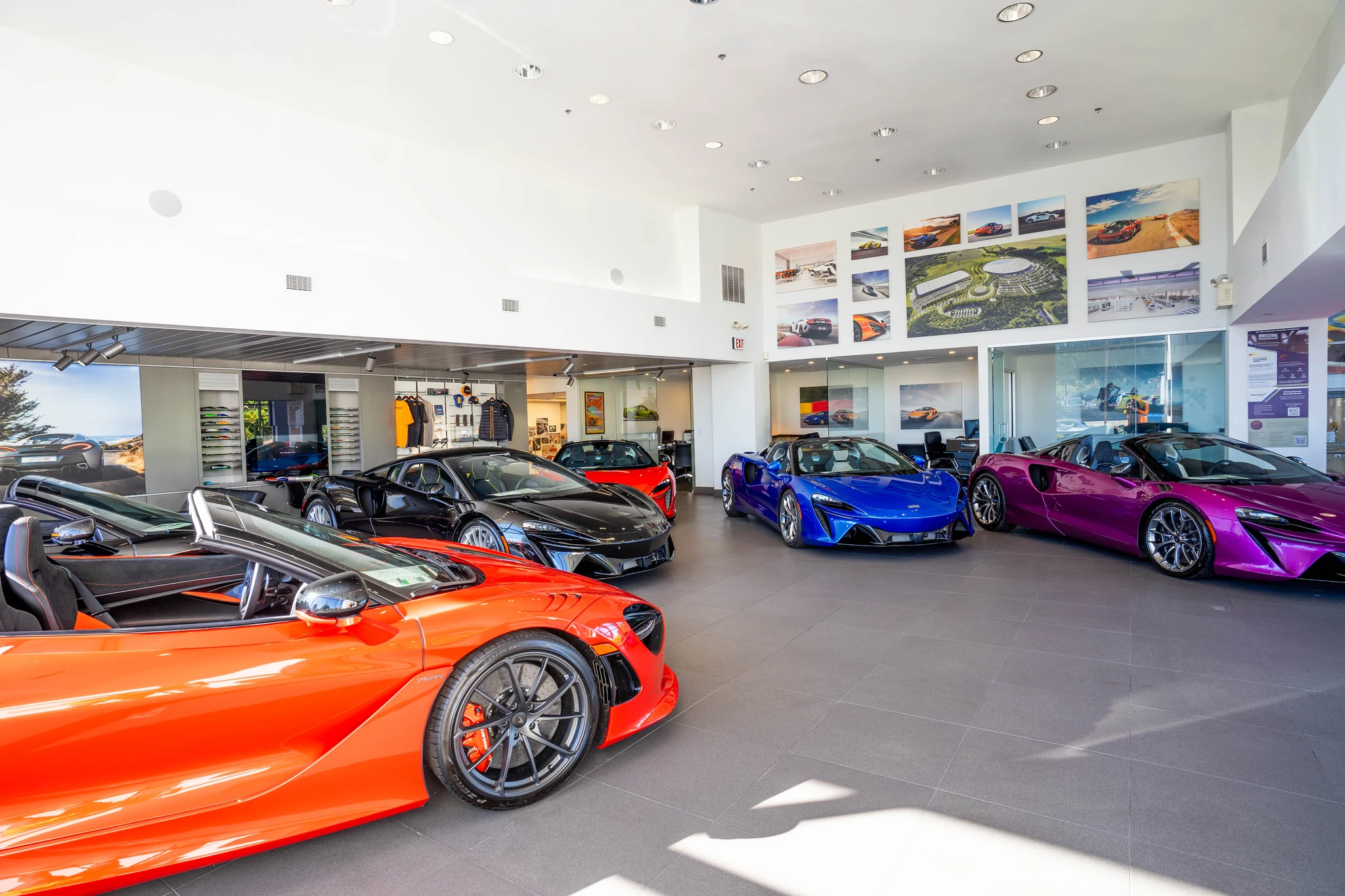 Inside the McLaren Boston showroom in Norwell, with several McLaren cars displayed beneath the marque’s wall photographs.