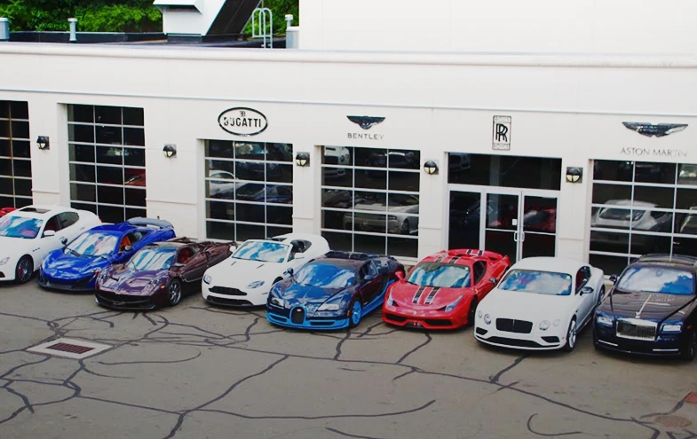 Miller Motorcars dealership facade in Greenwich, with luxury cars parked outside.