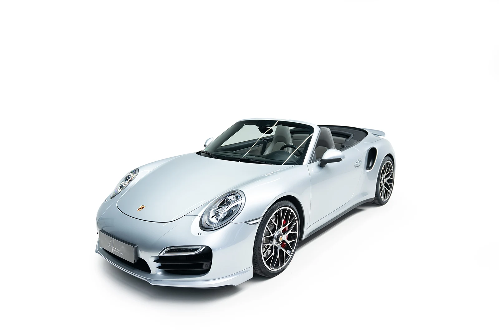 Silver Porsche 911 Turbo Cabriolet with the top down, full front three-quarter view