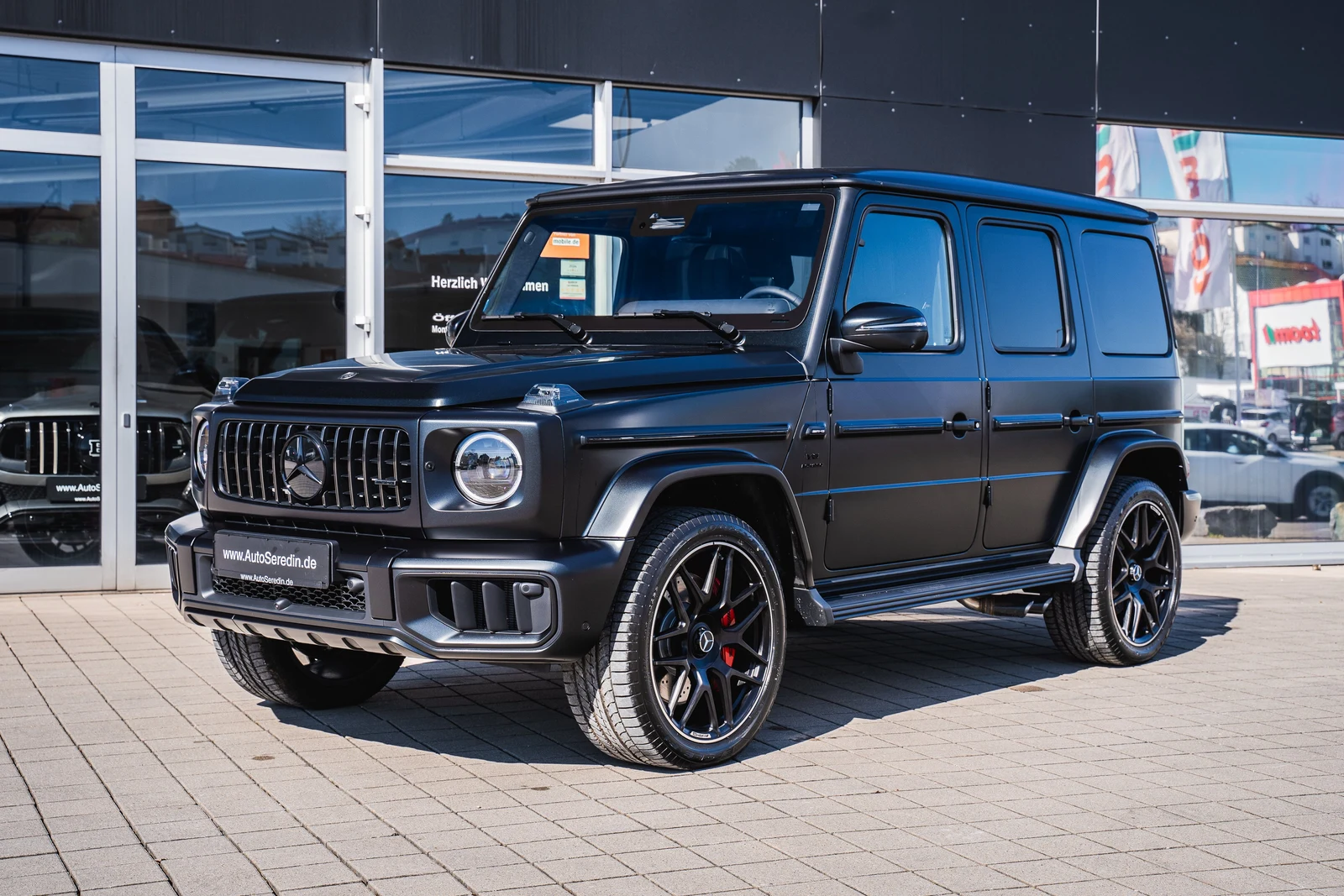 Matte black Mercedes-AMG G 63, full front three-quarter view