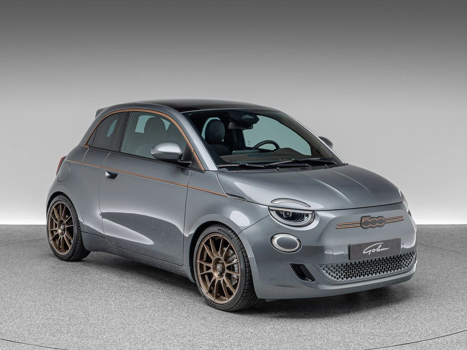 Fiat 500e Cabrio Versione Ambra by Gohm, full-car front three-quarter view.