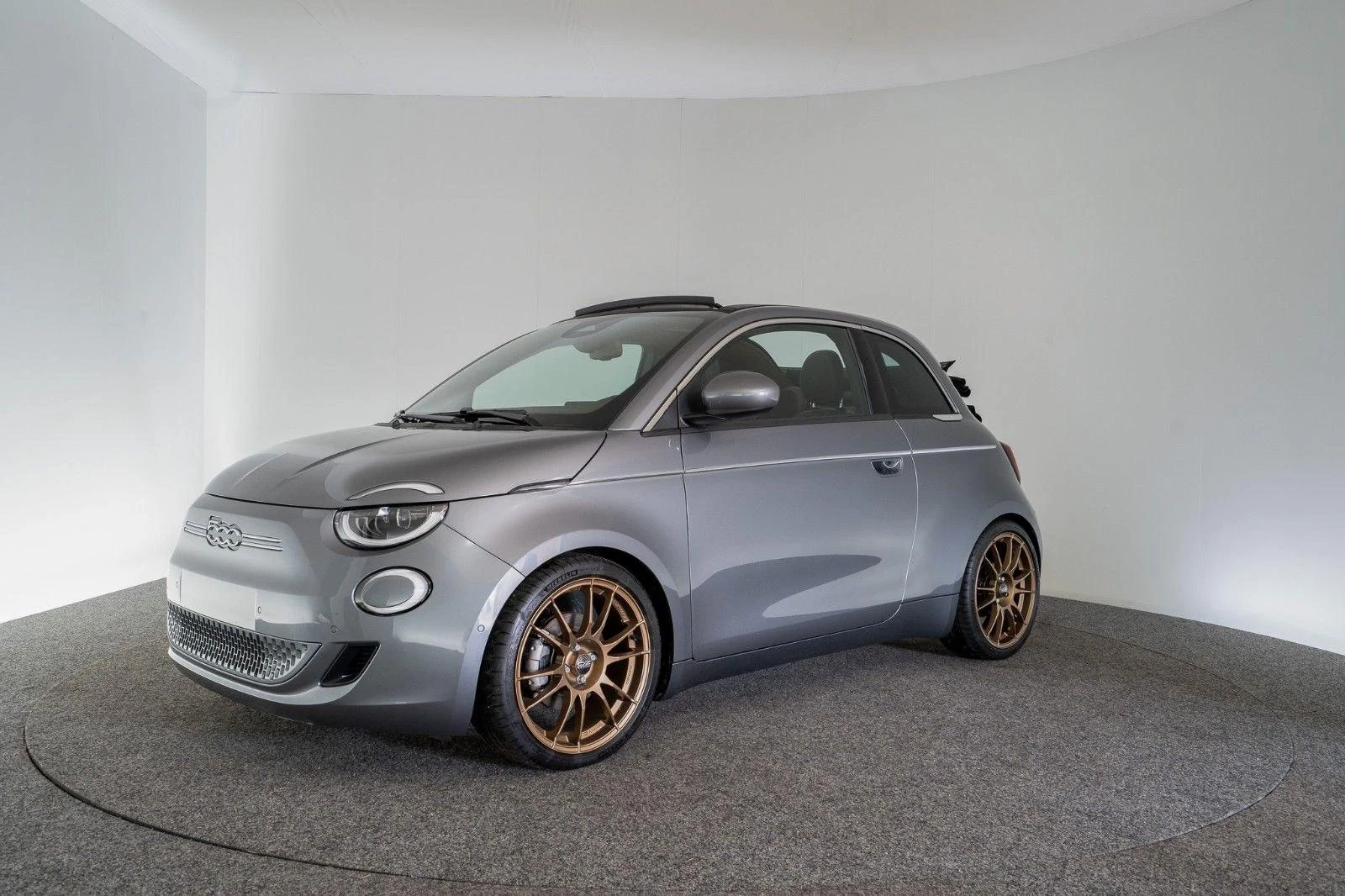 Fiat 500e Cabrio Versione Ambra by Gohm, full-car front three-quarter view.