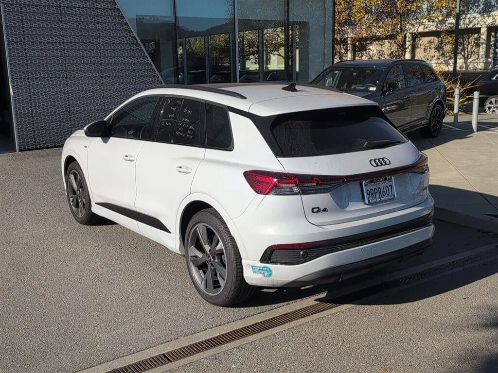 2024 Audi Q4 55 e-tron Premium Plus quattro, rear three-quarter view, Glacier White Metallic