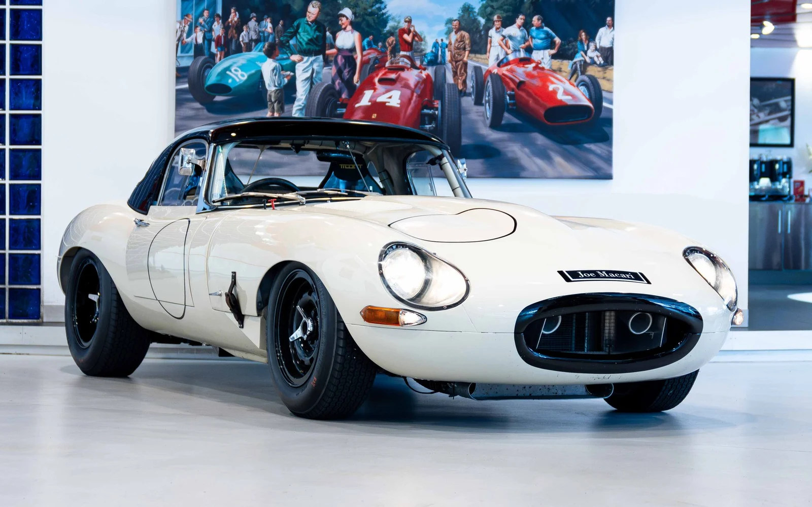 White competition Jaguar E-Type with hardtop, full front three-quarter view