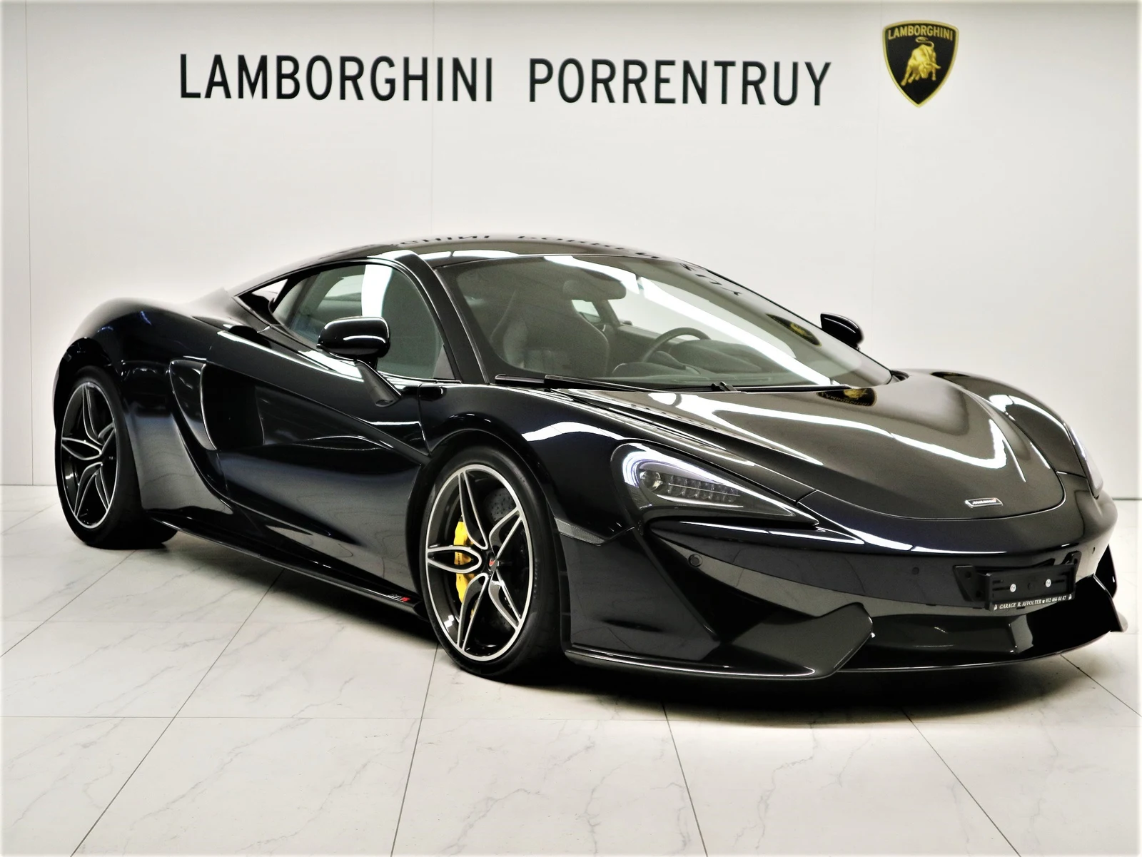 Black McLaren 570S, full front three-quarter view