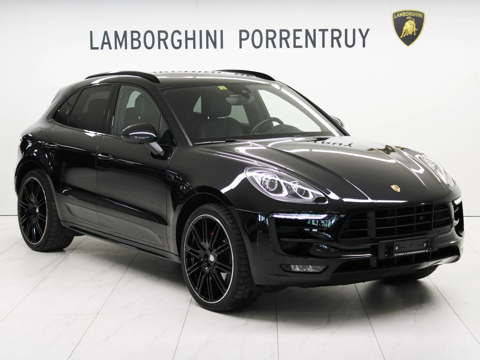Black Porsche Macan Turbo, full front three-quarter view